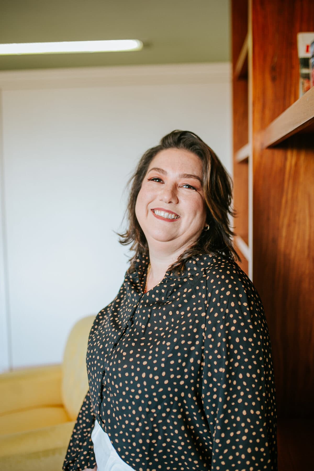 Michelle Mezzomo Luiz, psicóloga, sorrindo no consultório